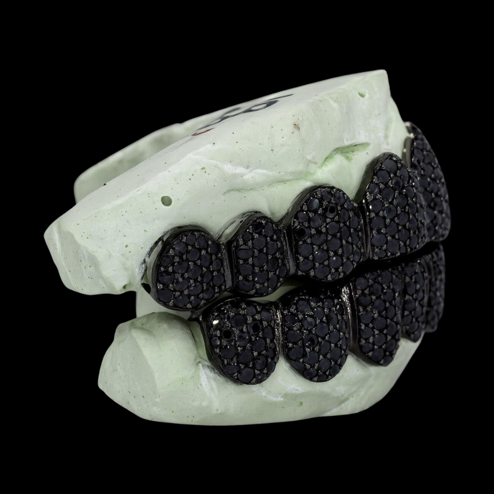 Side profile of custom black moissanite grillz showing three-dimensional fit and continuous stone coverage on dental arch