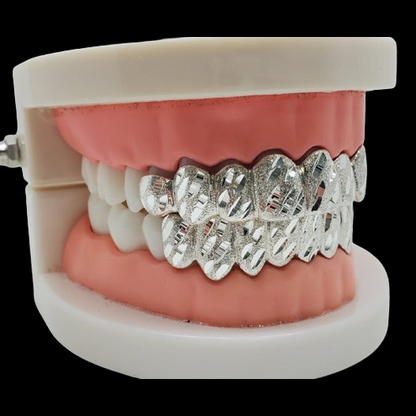 Custom nugget cut silver grillz on dental model showing full upper and lower fit