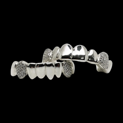 Diagonal view of silver fang grillz with polished center and stone sides