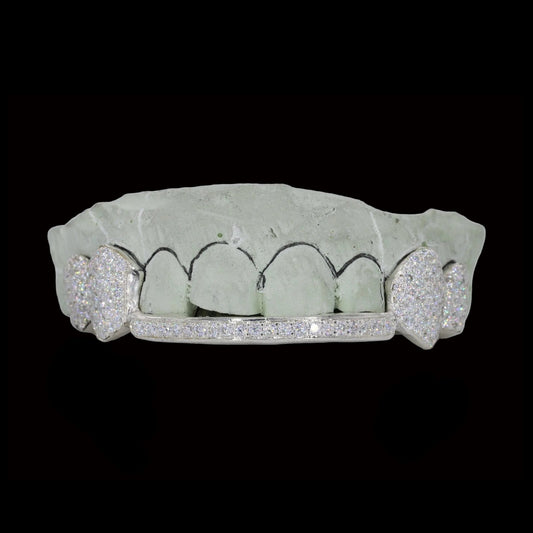 White gold diamond fang grillz with heart cutouts and channel-set lower bar on dental mold