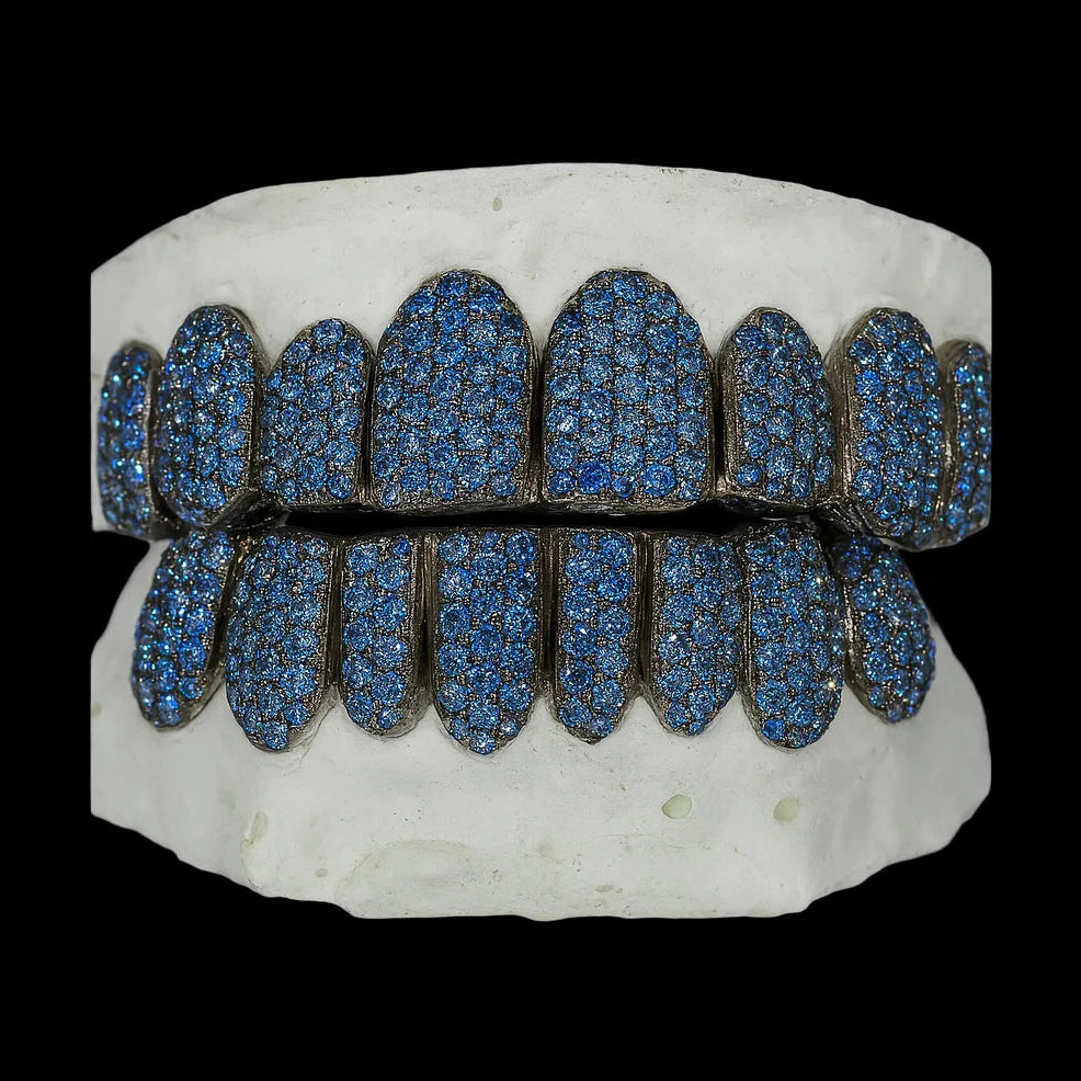 Symmetrical ice blue moissanite grillz showing full coverage of royal blue stones and dark oxidized framework