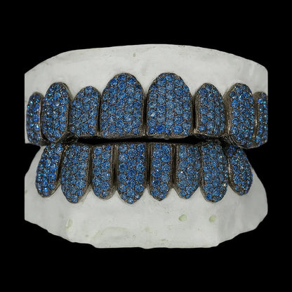 Symmetrical ice blue moissanite grillz showing full coverage of royal blue stones and dark oxidized framework