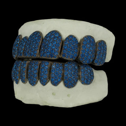 Angled view of custom ice blue moissanite grillz with matte dark metal edges and uniform stone paving
