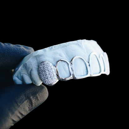 Close-up of custom open face grillz featuring dense pave stone setting