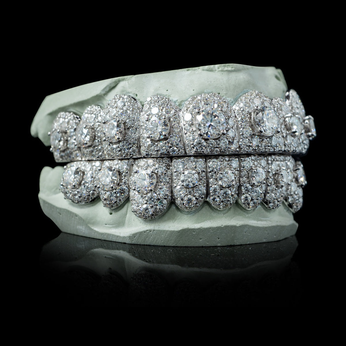 White gold moissanite grillz with dense pavé setting and large center stones on dental mold