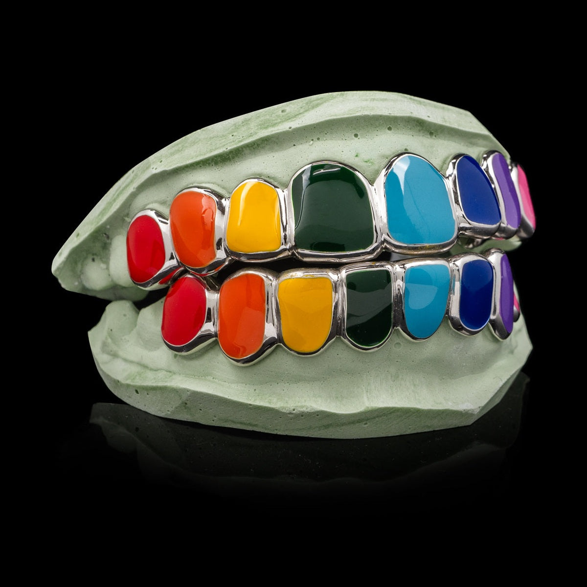 Close-up of rainbow enamel solid deep cut grillz highlighting glossy finish and metal edges
