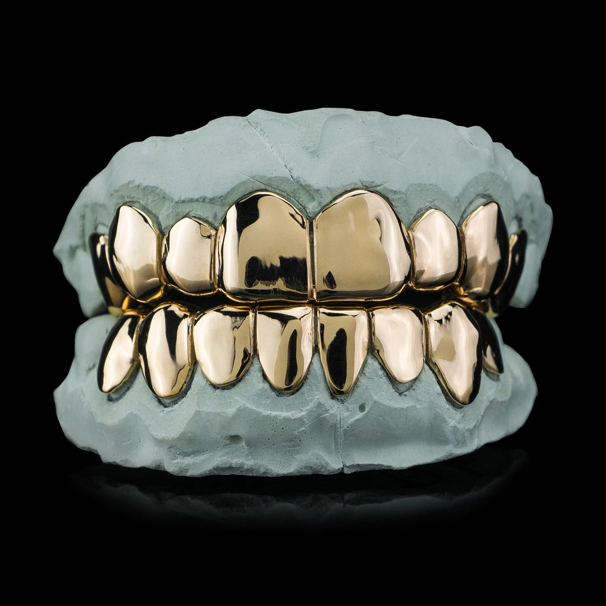 Yellow gold plated deep cut silver grillz on dental mold