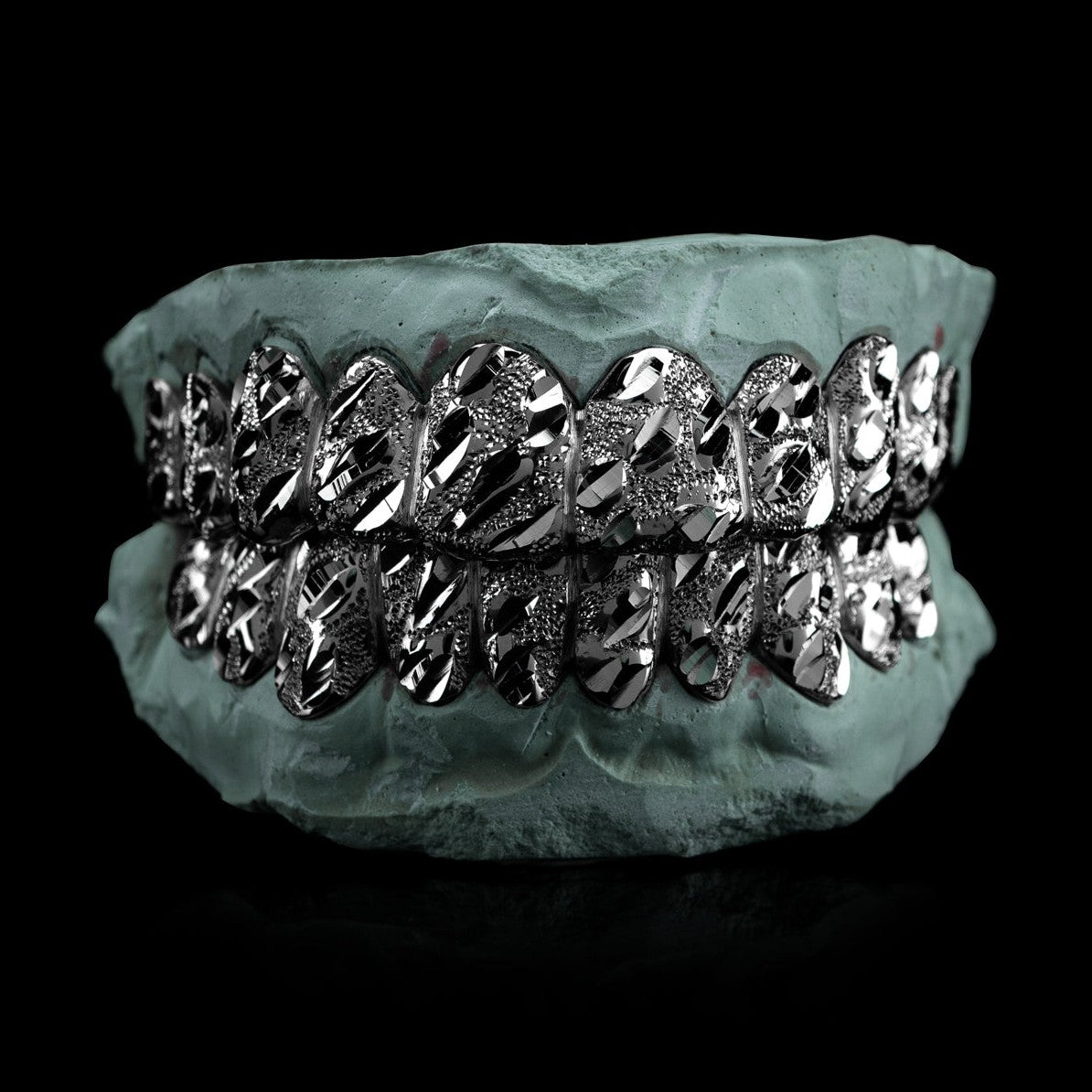 Silver nugget cut grillz featuring faceted diamond-cut pattern and angular grooves