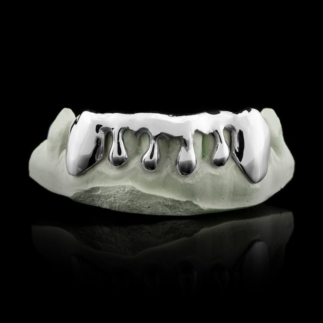 Solid sterling silver drip grillz with extended fangs and teardrop droplets on dental model