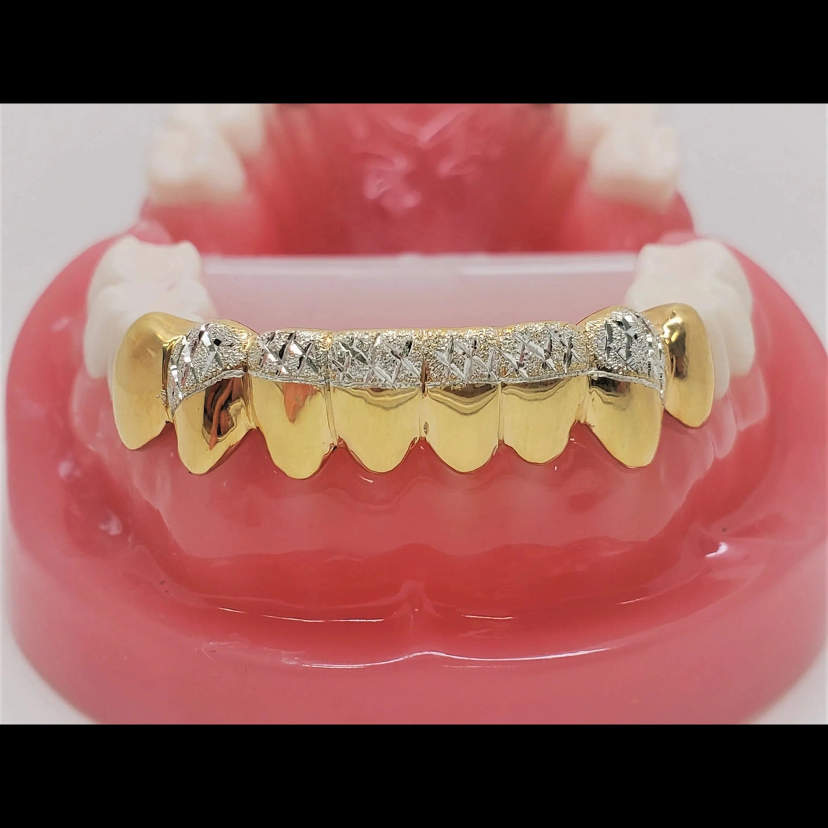 Side view of gold upper grill with diamond-cut texture