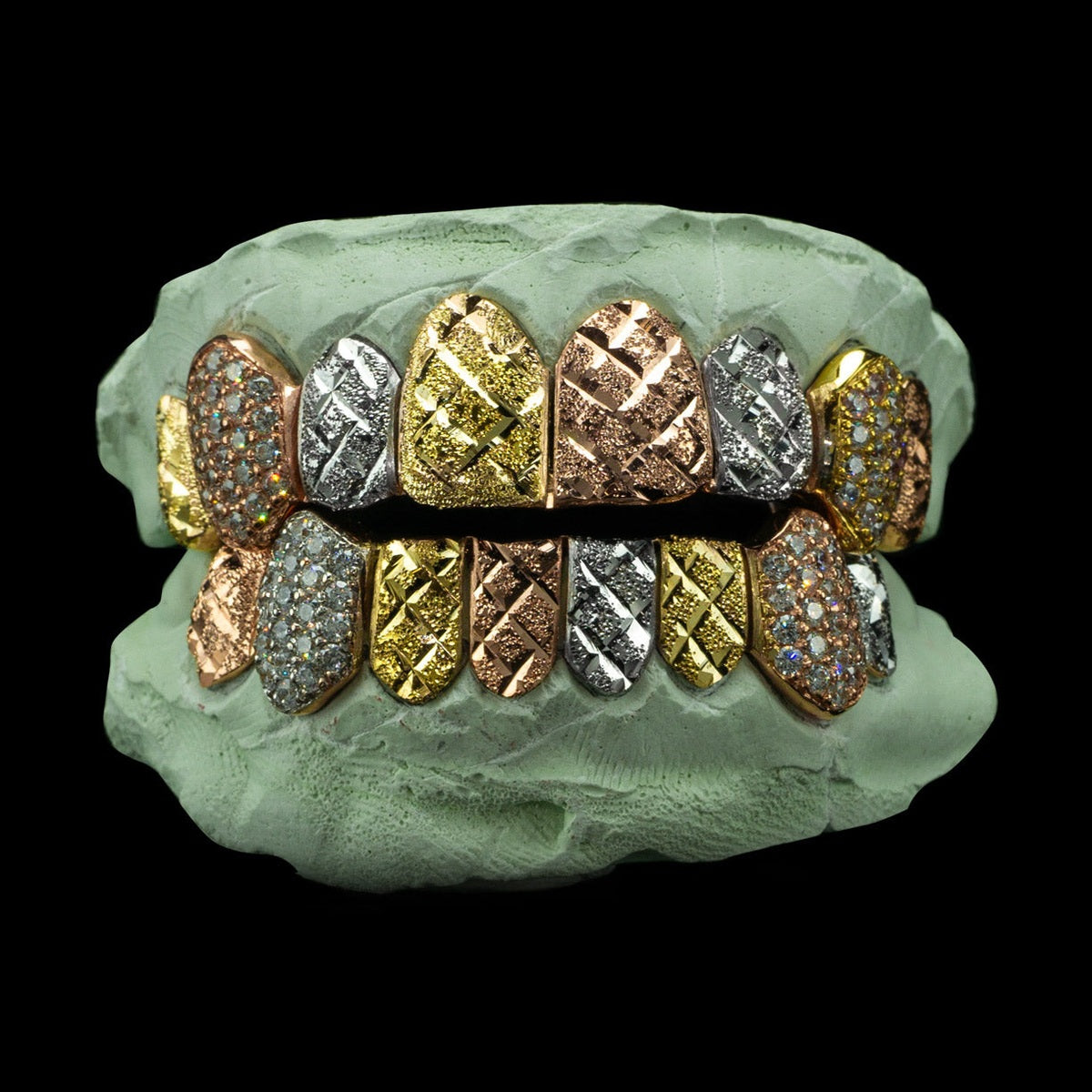 Tri-color 14k gold diamond cut grillz with iced out fangs on green mold