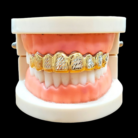 Front view of custom two-tone grillz with alternating diamond cut textures on a dental stand